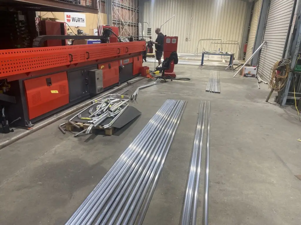 Probend's Akyapak ABM 50 CNC3 in the Invercargill workshop, with bent parts and straight tube laid out in front