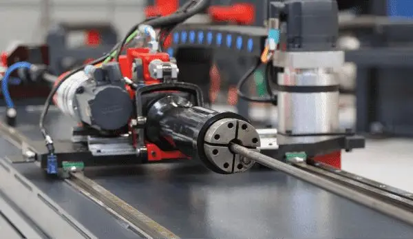 Servo-driven feed carriage and collet gripping a length of tube