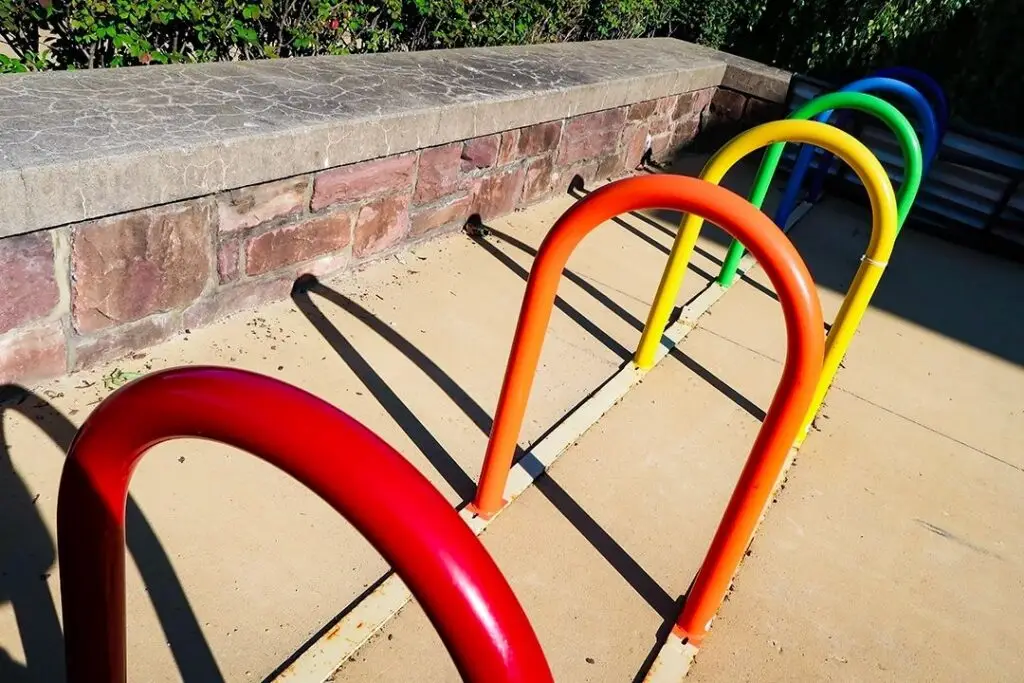 Row of bent tube bike racks powder coated in red, orange, yellow, green and blue