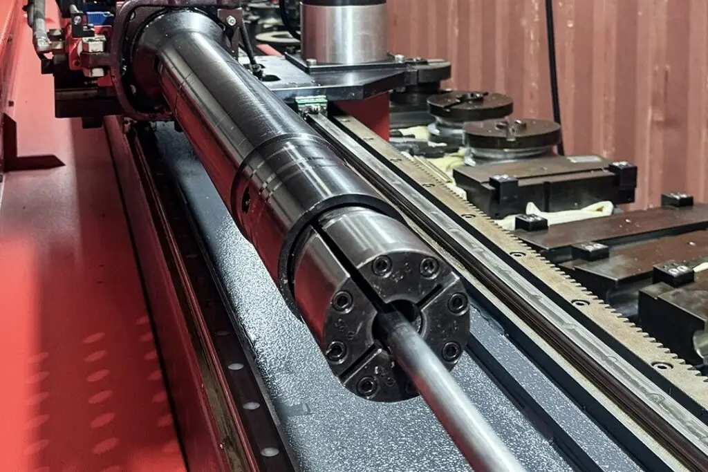 Feed carriage and collet of Probend's Akyapak tube bender gripping a length of tube