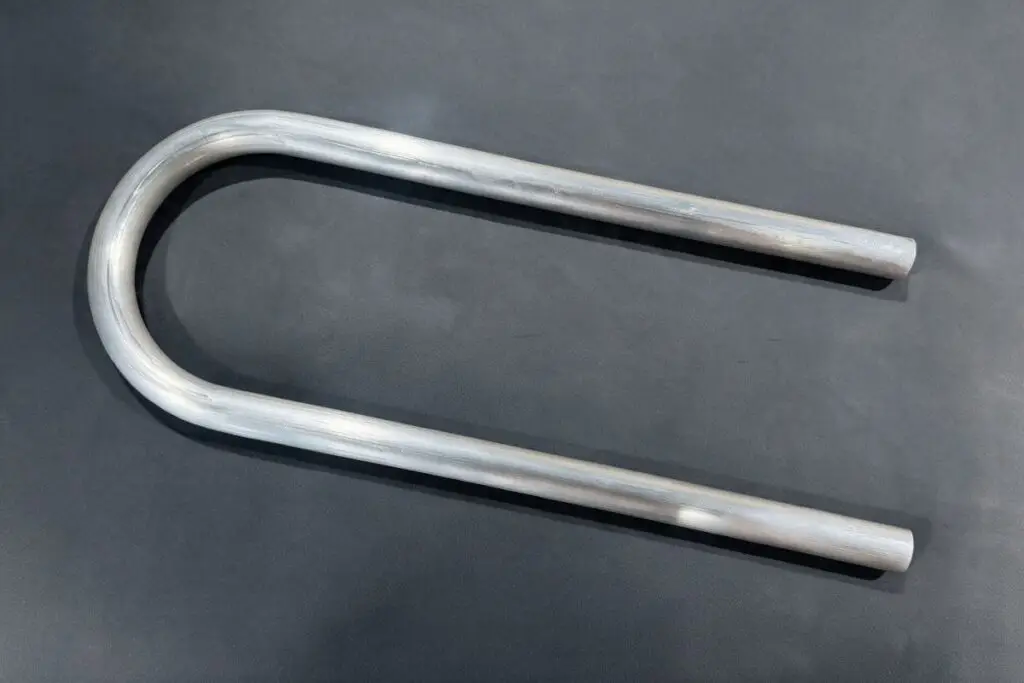 Aluminium tube bent into a U shape on a dark background